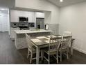 Open-concept kitchen and dining area with white cabinetry, stainless steel appliances, and ample seating at 8711 Rockingham Ter # D, Kissimmee, FL 34747