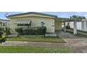 Quaint yellow mobile home with covered carport at 115 Palm Dr, Eustis, FL 32726