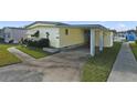 Mobile home with carport, landscaping, and walkway at 115 Palm Dr, Eustis, FL 32726