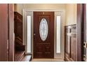 Interior view of the foyer with a brown wooden door, sidelights, and wood-paneled walls at 1413 Dorothy Ave, Haines City, FL 33844
