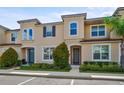 Exterior view of a two-story townhome with landscaped front yard and driveway at 1567 Carey Palm Cir, Kissimmee, FL 34747