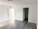 Empty bedroom with gray wood-look flooring, white walls, and access to a bathroom at 2449 Sunset Dr, Lake Wales, FL 33898