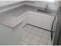 Bright, spacious kitchen with white cabinetry, granite countertops, and tile flooring at 2449 Sunset Dr, Lake Wales, FL 33898