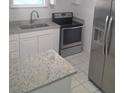 Modern kitchen featuring white shaker cabinets, granite countertops, and stainless steel appliances at 2449 Sunset Dr, Lake Wales, FL 33898