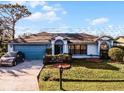 House with a blue garage door, landscaping, and a driveway at 532 Maricopa Dr, Kissimmee, FL 34758