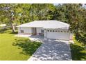 Front view of a single-story home with an attached garage, driveway, and green lawn at 1469 Swan Pl, Kissimmee, FL 34759