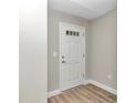 White interior door with a window at the top, wood-look flooring, and neutral-colored walls at 199 Juniper Way, Ocala, FL 34472
