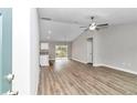 Open-concept living area with wood-look flooring, ceiling fan, and access to the kitchen and dining area at 199 Juniper Way, Ocala, FL 34472