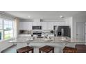 Modern kitchen featuring white shaker cabinets, granite countertops, stainless steel appliances, and ample natural light at 2765 Flushing Dr, Apopka, FL 32703