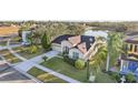Elevated view of a home with a brown tile roof, a driveway, and lush landscaping at 2920 Orangebud Dr, Kissimmee, FL 34746