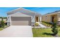 Inviting home exterior with a paved driveway, attached garage, and landscaped walkway at 4148 Lavender Ct, Lake Hamilton, FL 33851
