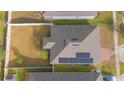 An aerial view showcasing the home's roof, solar panels, and fenced backyard at 473 Disa Dr, Davenport, FL 33837