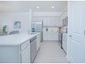 Modern kitchen featuring white cabinetry, stainless steel appliances, and an island at 473 Disa Dr, Davenport, FL 33837