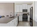 Modern kitchen with stainless steel appliances and white cabinets at 781 Ocean Course Ave # 601, Davenport, FL 33896