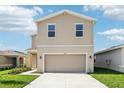 Two-story home with light tan siding, a two-car garage, and a concrete driveway at 4144 Lavender Ct, Lake Hamilton, FL 33851