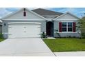 One-story home with gray siding, white garage door, and red shutters at 811 Turner Ln, Winter Haven, FL 33881