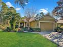 House exterior featuring a two-car garage and lush landscaping at 310 Stonington Way, Deland, FL 32724