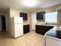 Kitchen with dark cabinets and white appliances at 5165 Gwynne Ave, Orlando, FL 32810