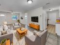 Bright living room with tiled floors, comfy seating, and a view into the kitchen at 7008 Watseka Ave, Orlando, FL 32818