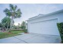 White two-car garage with driveway at 8100 Fan Palm Way, Kissimmee, FL 34747