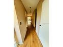 Long hallway with light brown laminate flooring leading to other rooms at 10 Moree Loop # 13, Winter Springs, FL 32708