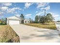 Newly built home with a long driveway and light gray siding at 1609 Pickerel Ct, Kissimmee, FL 34759