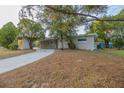 Tan house with long driveway and mature trees at 5815 Harrington Dr, Orlando, FL 32808