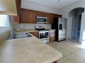 Modern kitchen with stainless steel appliances and wood cabinets at 7128 Five Oaks Dr, Harmony, FL 34773