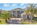 Two-story house, gray exterior, paver driveway, palm trees, and green lawn at 9168 Lake Avon Dr, Orlando, FL 32829