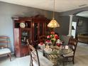 Formal dining area with a glass-top table and wooden hutch at 1403 Kissimmee Ct, Kissimmee, FL 34759