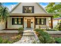 White brick home with a wood front porch and a charming bench at 2330 Westminster Ct, Winter Park, FL 32789