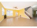 Spacious living room with yellow walls, tile floors, and staircase at 3279 Fairfield Dr, Kissimmee, FL 34743