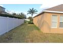 Side yard with a grassy area and white vinyl fence at 428 Palastro Ave, Auburndale, FL 33823