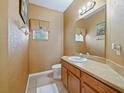 Neat and clean half bathroom with wood vanity and tile flooring at 1542 Travertine Ter, Sanford, FL 32771