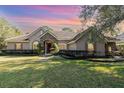 One-story house with stone accents, red door, and nicely landscaped lawn at 25628 Hawks Run Ln, Sorrento, FL 32776