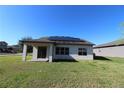Home's back features a covered patio and solar panels at 684 Bishop Bay Loop, Apopka, FL 32712