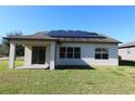 Home's back features a covered patio and solar panels at 684 Bishop Bay Loop, Apopka, FL 32712