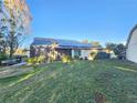 Backyard view, showing a large grassy area and solar panels at 1022 Bartlett Ct, Oviedo, FL 32765