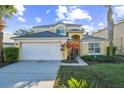 Two-story house with tan exterior, white garage door, and landscaping at 8458 Secret Key Cove, Kissimmee, FL 34747