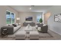 Living room with gray and white furniture, and a large TV at 1245 Limbali St, Mount Dora, FL 32757