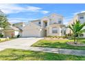 Two-story house with beige exterior, attached garage, and landscaping at 128 Higher Combe Dr, Davenport, FL 33897