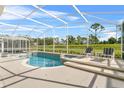 Relaxing screened pool area with lounge chairs and view of the golf course at 128 Higher Combe Dr, Davenport, FL 33897