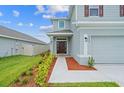 Two-story home's front entrance with walkway and landscaping at 3019 Tackle Dr, Leesburg, FL 34748