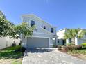 Two-story house with gray siding, gray garage door, and a paved driveway at 8956 Zurich Ln, Kissimmee, FL 34747