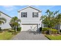 Two-story house with gray siding, white garage door, and landscaped front yard at 1627 Kona Ln, Davenport, FL 33897