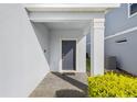 Gray front door with a covered entryway and brick pavers at 1627 Kona Ln, Davenport, FL 33897