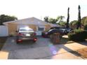 House exterior showcasing a yellow single-story home with a two-car garage and a partially visible driveway at 2214 Winnetka Ct, Orlando, FL 32818