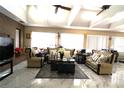 Spacious living room with beige sofas, a marble floor, and a large TV at 2214 Winnetka Ct, Orlando, FL 32818