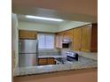 Galley kitchen with stainless steel appliances and granite countertops at 348 Scottsdale Sq # 348, Winter Park, FL 32792