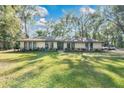House exterior showcasing a manicured lawn and mature trees at 1660 Killean Ct, Apopka, FL 32712